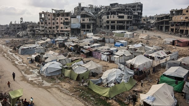 Palestinians walk around their tents in Gaza City