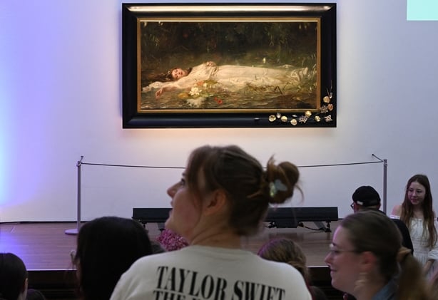 Fans of US singer-songwriter Taylor Swift and other visitors listen to a lecture about the painting Ophelia (circa 1900) by German artist Friedrich Heyser during a short guided tour at Museum Wiesbaden in Wiesbaden, Germany on 2 November 2025
