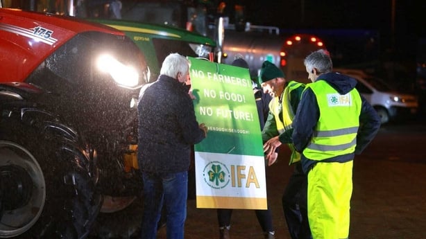 Men stand next to tractor 