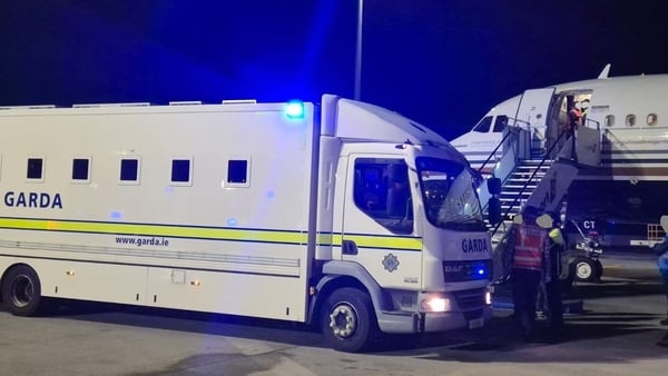 A garda van is seen with an plane in the background