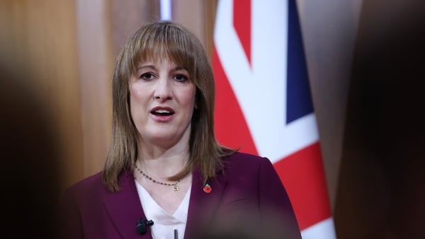 Image of a woman in a suit with a Union Jack flag in the background