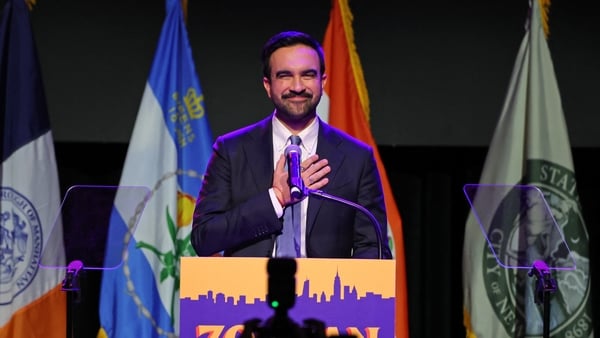 Zohran Mamdani stands on stage