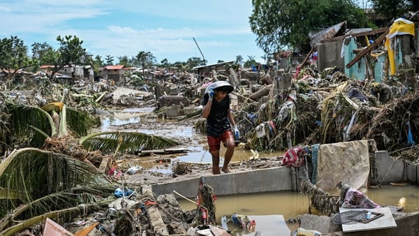 A resident walks through debris after a typhoon