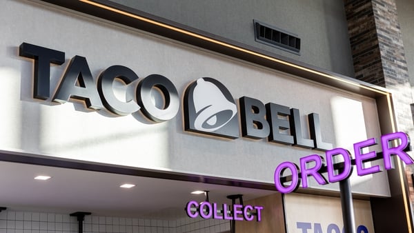 A Taco Bell logo and order and collect signs at a motorway reststop