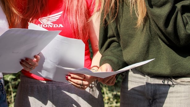 Three girls hold A4 pages