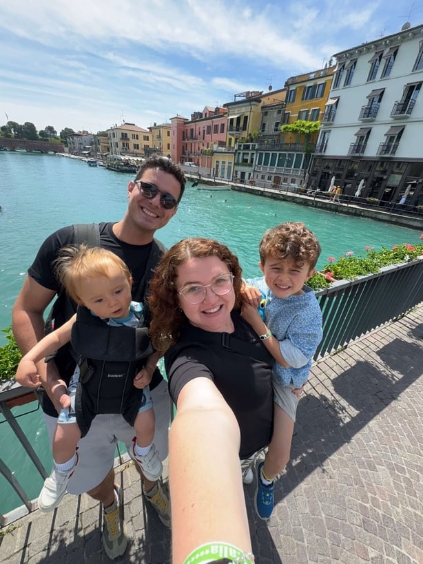 A couple and their two children posing for a photo beside a canal