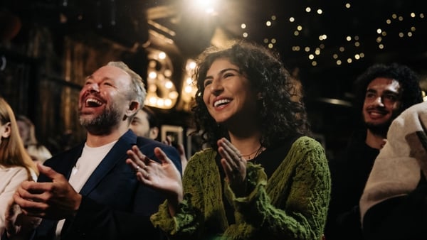 man and woman laughing at comedy show