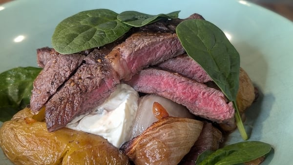 A plate of steak served with soft cheese and onions