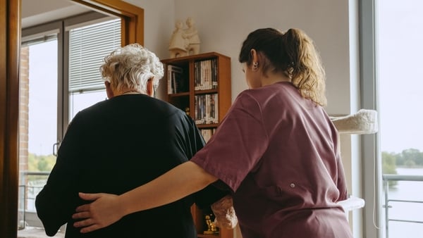 Image of a carer helping an elderly woman in her home