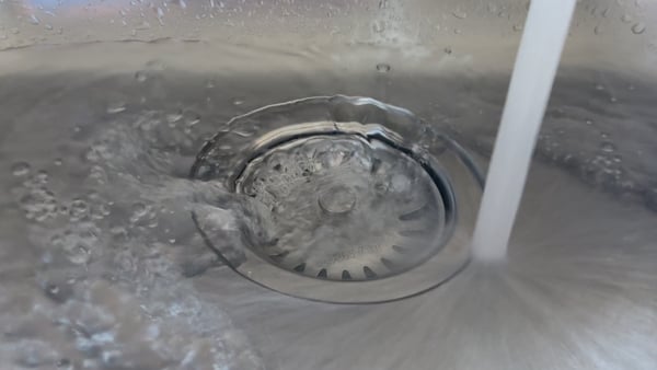 Image shows a close-up of water going down the drain in a sink