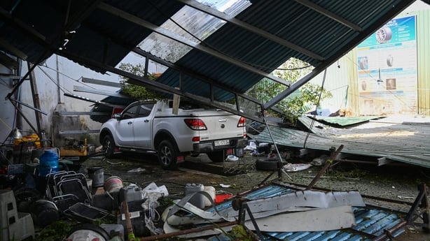 A vehicle stuck under a collapsed roof structure in central Vietnam.