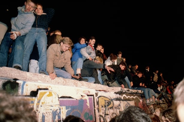 People climb on the Berlin Wall after opening of the border on November 9, 1989