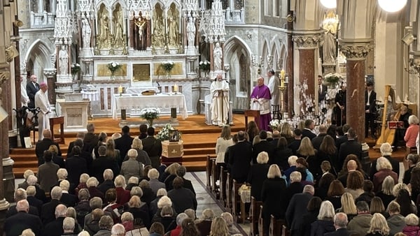People gathered in a church for the funeral of Sr Stan