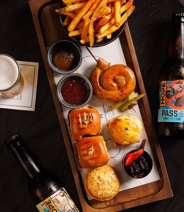 An overhead shot of the Gentleman's Tea at The Morrison, showing mini sliders, fries, scones and sauces.