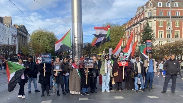 Protesters are seen at the Spire on O'Connell Street holding Sudanese flags