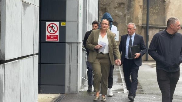 Paul Sheehan walks outside court, obscured behind others