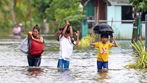 Residents evacuate from their flooded homes due to heavy rain brought by Typhoon Fung-wong