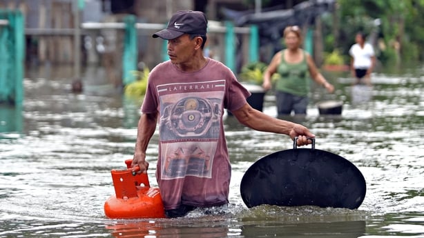 Residents evacuate from their flooded homes due to heavy rain brought by Typhoon Fung-wong