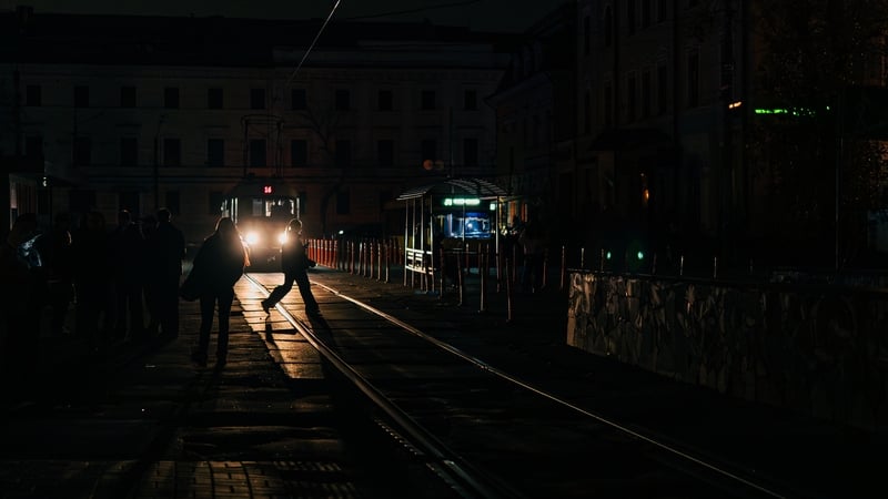 People walk through the darkened streets of Podil district amid power outages following Russian strikes on Kyiv, Ukraine