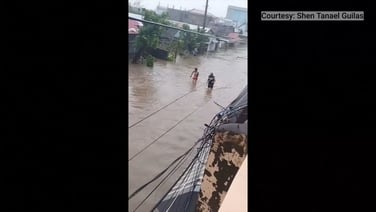 Residents wade through floodwaters in Bagamanoc, Philippines