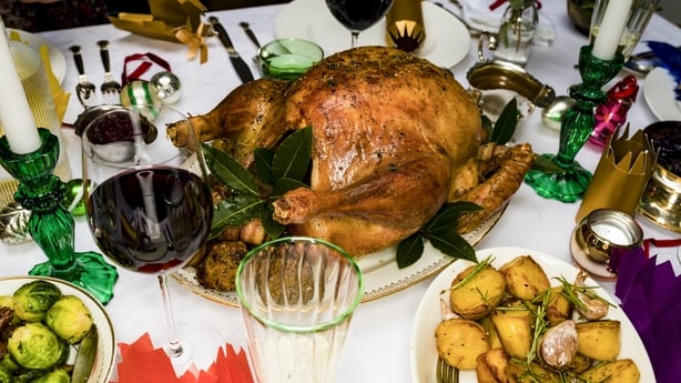 Roasted Christmas Turkey And Potatoes On Dining Table With Red Wine And Christmas Decorations