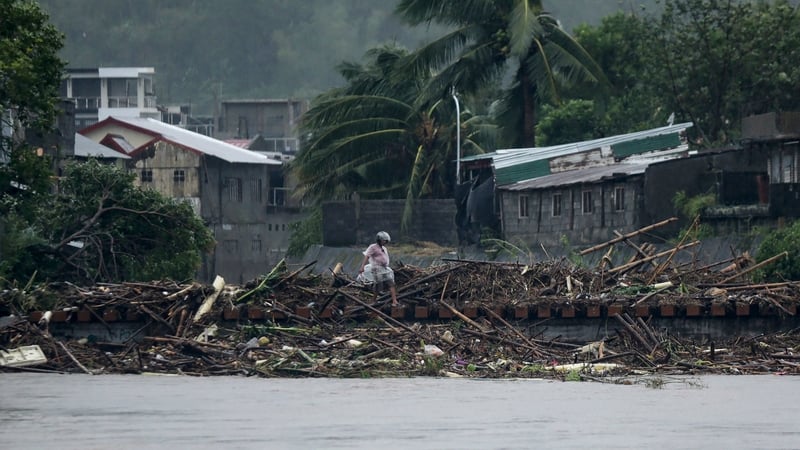 A man walks past debris along the shores of a river at Polangui in Albay province in the Philippines