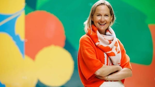 Image of a lady in brightly coloured wool jumper and scarf