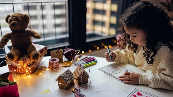 Little girl drawing Christmas cards at home