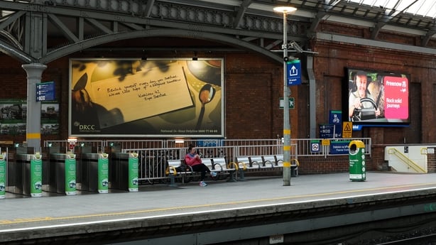 A sign of hope message can be seen on a large billboard inside a train station