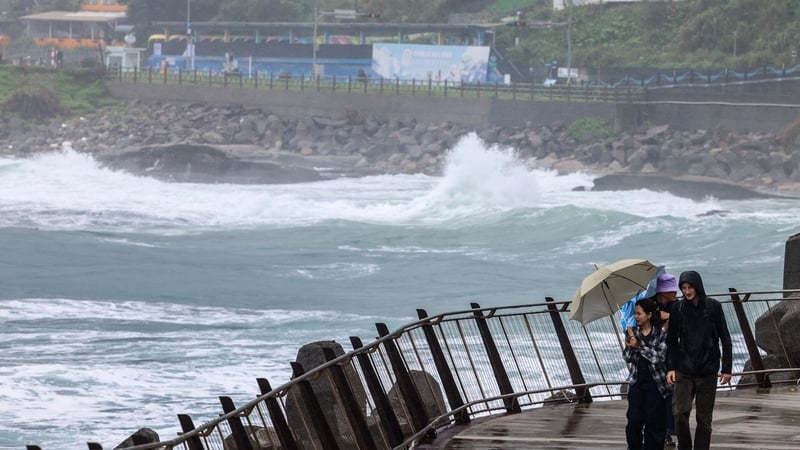 People shield from the rain and the wind as Typhoon Fung-wong approaches in Taiwan