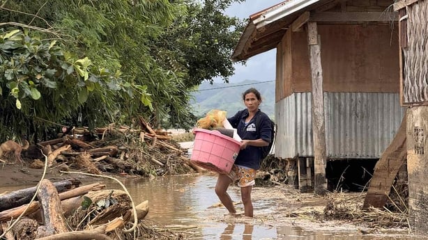 A woman carrying belongings evacuates from her flood-hit home in Tuao town, Cagayan province