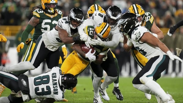 Bo Melton of the Green Bay Packers is swarmed by Kylen Granson (83), Jeremiah Trotter Junior (54) and Joshua Uche (0) of the Philadelphia Eagles