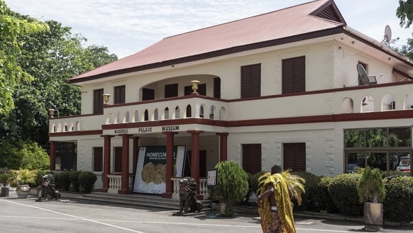 A man walks past the Manhyia Palace Museum in Kumasi, Ghana