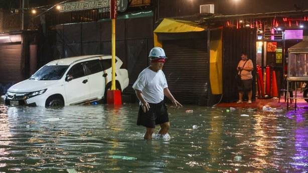 NAVOTAS, METRO MANILA, PHILIPPINES - NOVEMBER 10: An elderly man with a helmet walks in a flooded area near the coast, after super Typhoon Fung-Wong (Uwan) hit the country, causing floods, blackouts and killing at least two, in Navotas, Metro Manila, Philippine, on November 10, 2025. Typhoon Fung Wo