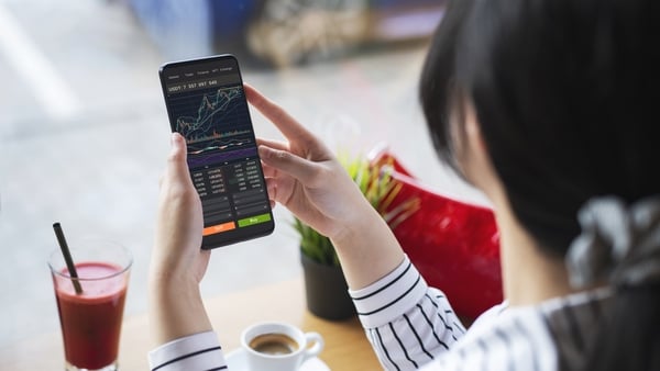 The convenience of investing in crypto in that you can do it anytime anywhere.Woman using smartphone to buy cryptocurrency at a coffee shop, blockchain investment, decentralize and Stock market concept.