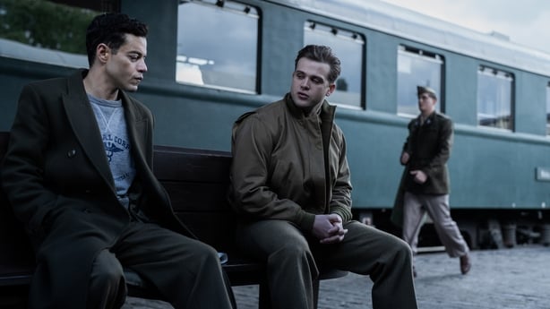 (L-R) Rami Malek as Douglas Kelley and Leo Woodall as Sgt Howie Triest at a train station in Nuremberg