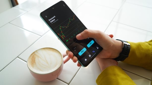 Young hijab woman checking investment and stock with mobile apps on smart phone