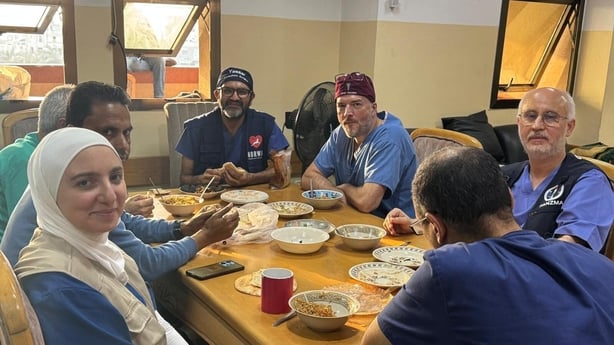  Dr Morgan McMonagle sits around a table with colleagues in gaza 