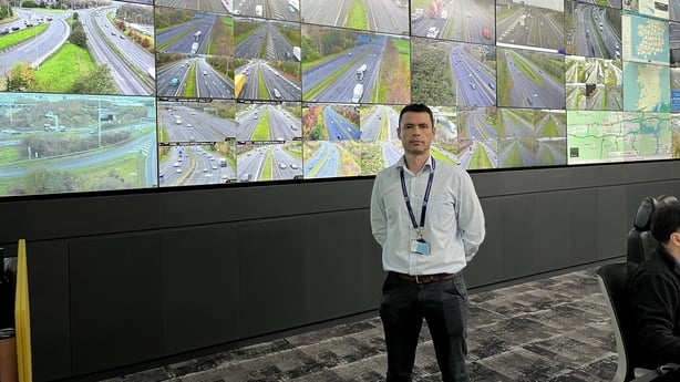 TII Motorway Operations Manager Daniel Pentony stands in front of several screen showing footage of the M50