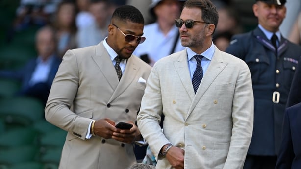 LONDON, ENGLAND - JULY 04: Boxing promoter Eddie Hearn and professional boxer Anthony Joshua take their seats in the royal box ahead of the Gentlemen's third round match between Taylor Fritz of United States and Alejandro Davidovich Fokina of Spain on day five of The Championships Wimbledon 2025 at 