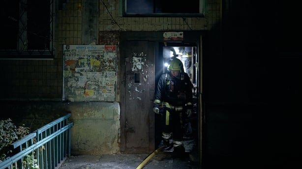 Members of the State Emergency Service of Ukraine exit a damaged building in Kyiv.
