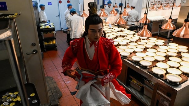 Man in traditional Chinese clothes in a restaurant kitchen 