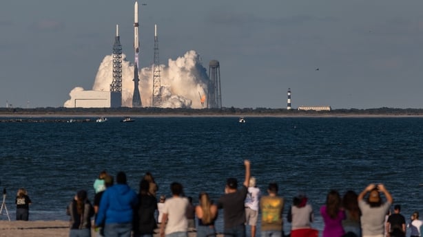 People at the beach in Cape Canaveral watch Blue Origin's New Glenn rocket lift off
