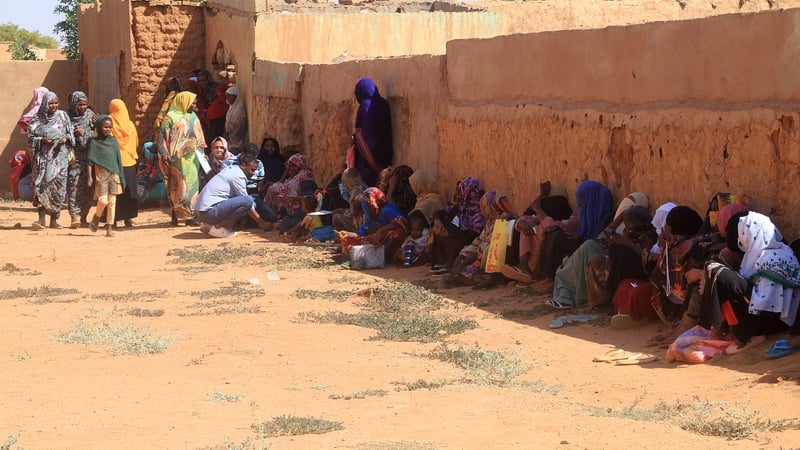 Displace people from El-Fasher take shelter beside a wall at in Omdurman, part of greater Khartoum