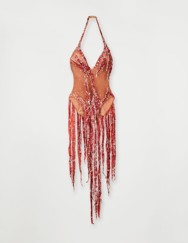 A red bodysuit with fringe and crystals created by Bob Mackie