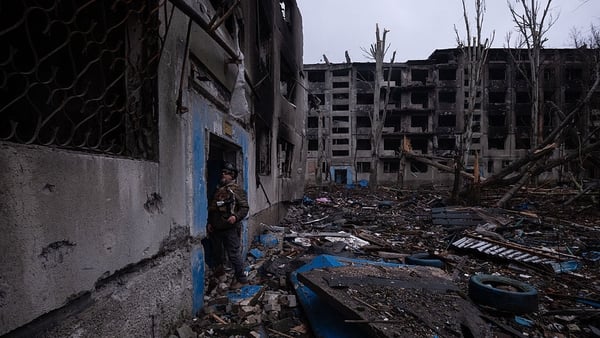Ukrainian serviceman standing next to destroyed buildings in the frontline town of Kostyantynivka, Donetsk region