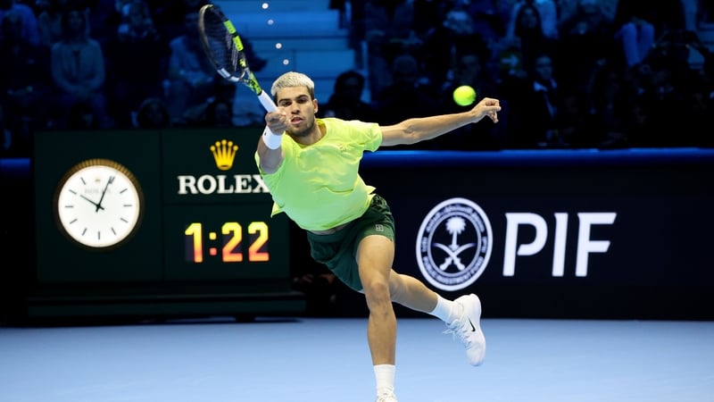 Carlos Alcaraz stretches for a forehand return against Felix Auger-Aliassime