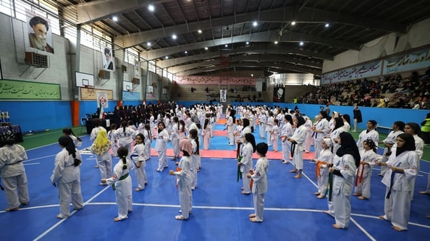 Fans look on as Women and girls gather prior to the start of a karate competition