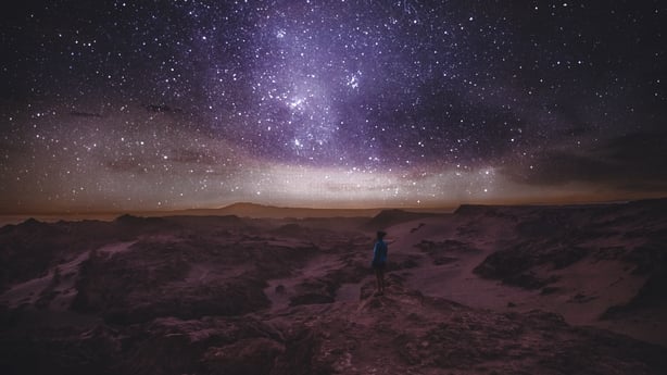 Woman enjoying stargazing under the night sky with million of stars