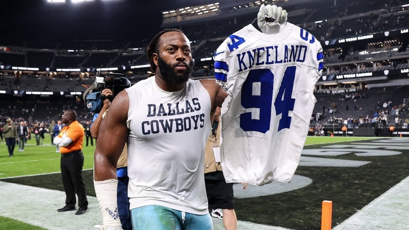 Osa Odighizuwa of the Dallas Cowboys walks off the field at Allegiant Stadium holding a number 94 jersey in remembrance of Marshawn Kneeland